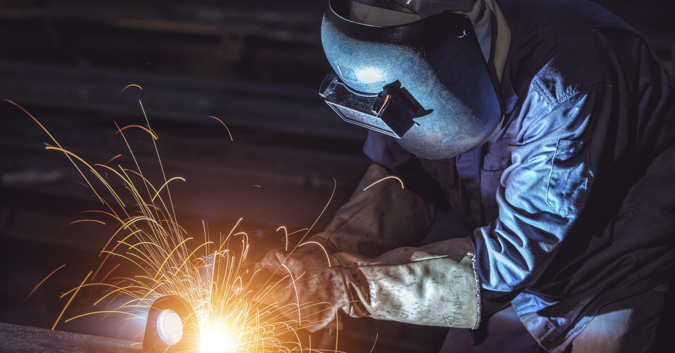 Industrial Worker labourer at the factory welding steel structure